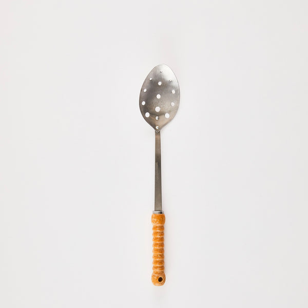 Silver slotted kitchen spoon with wooden handle.