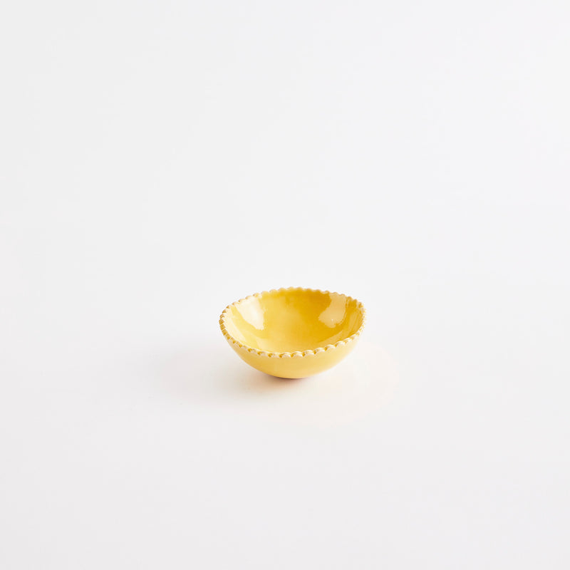 Yellow pinch pot with scalloped edges.