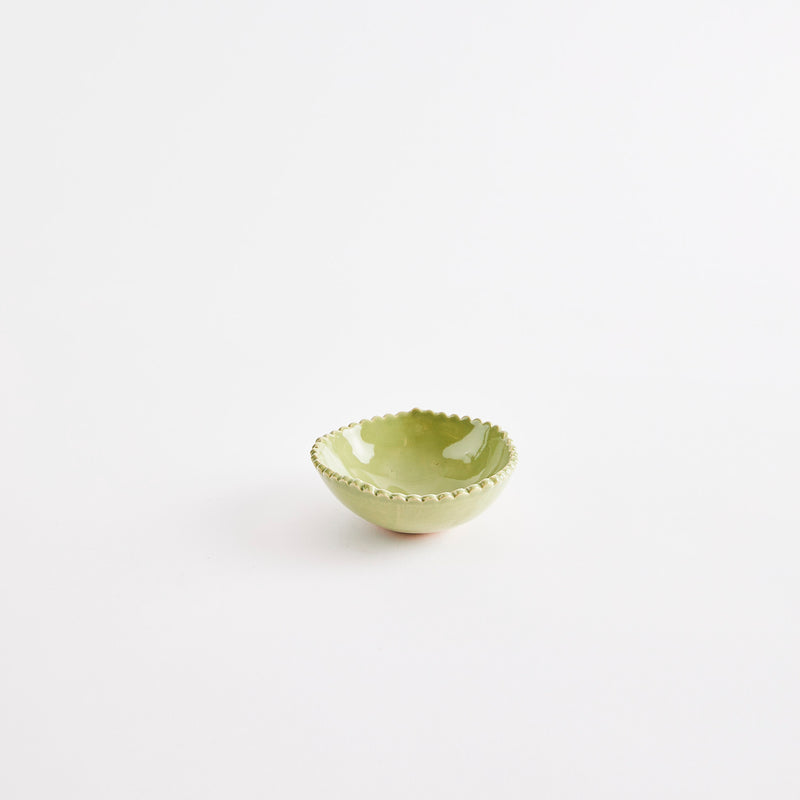 Green pinch pot with scalloped edges.