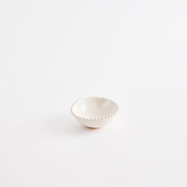 White pinch pot with scalloped edges.