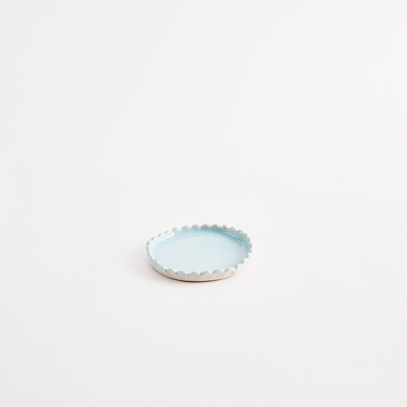 Blue flat pinch pot with scalloped edges.