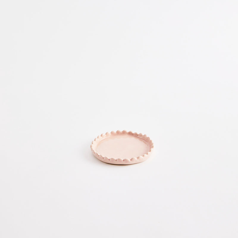 Light pink flat pinch pot with scalloped edges.