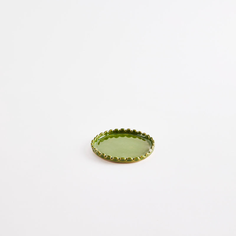 Olive green flat pinch pot with scalloped edges.