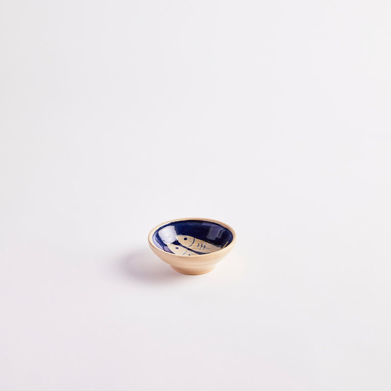 Cream with navy detailing of two fish inside pinch pot. 