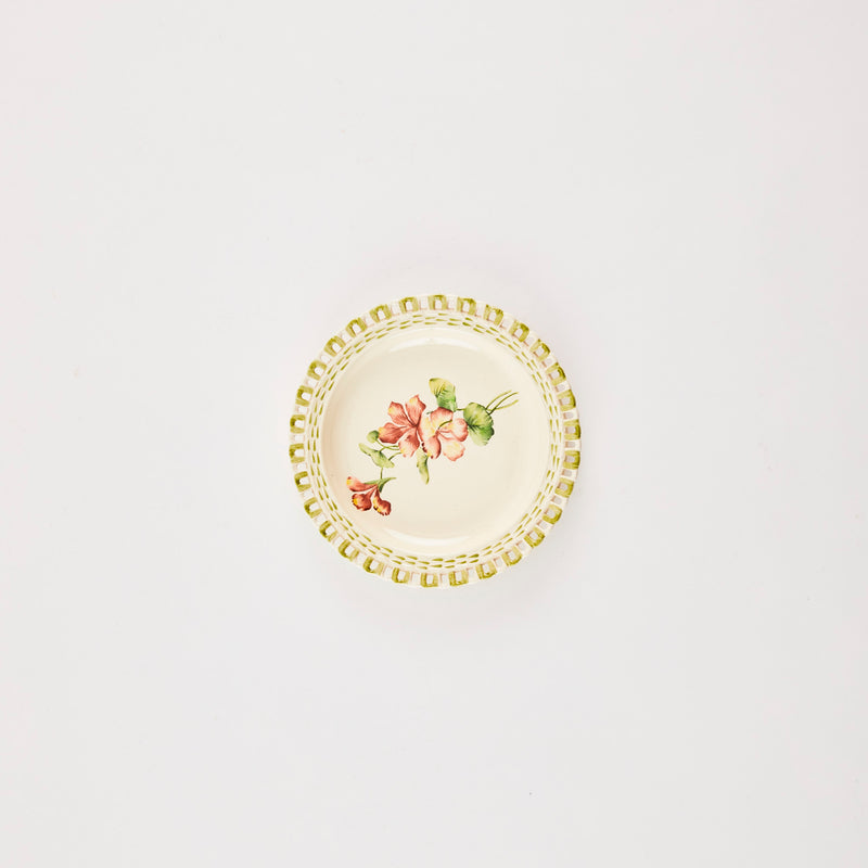 White and green plate with flower print in the middle.