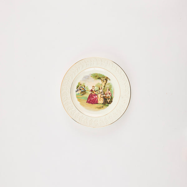 White plate with embossed edge and period art of five people in middle.