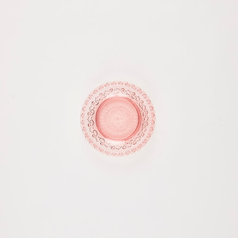 Pink glass plate with embossed detail.