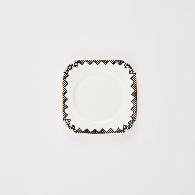 White square plate with monochrome edge and gold rim.