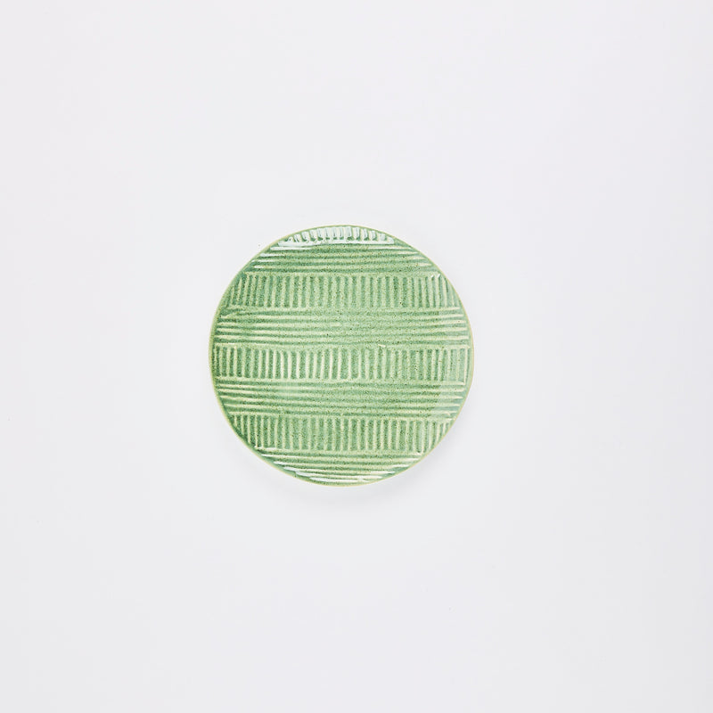 Green ceramic plate with embossed lines design.