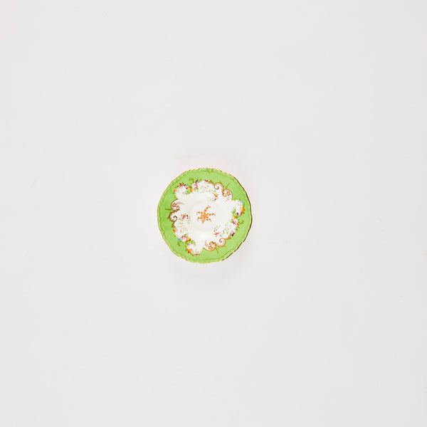 White plate with green rim and floral detail.