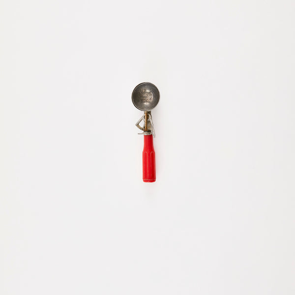 Silver scoop with red handle.