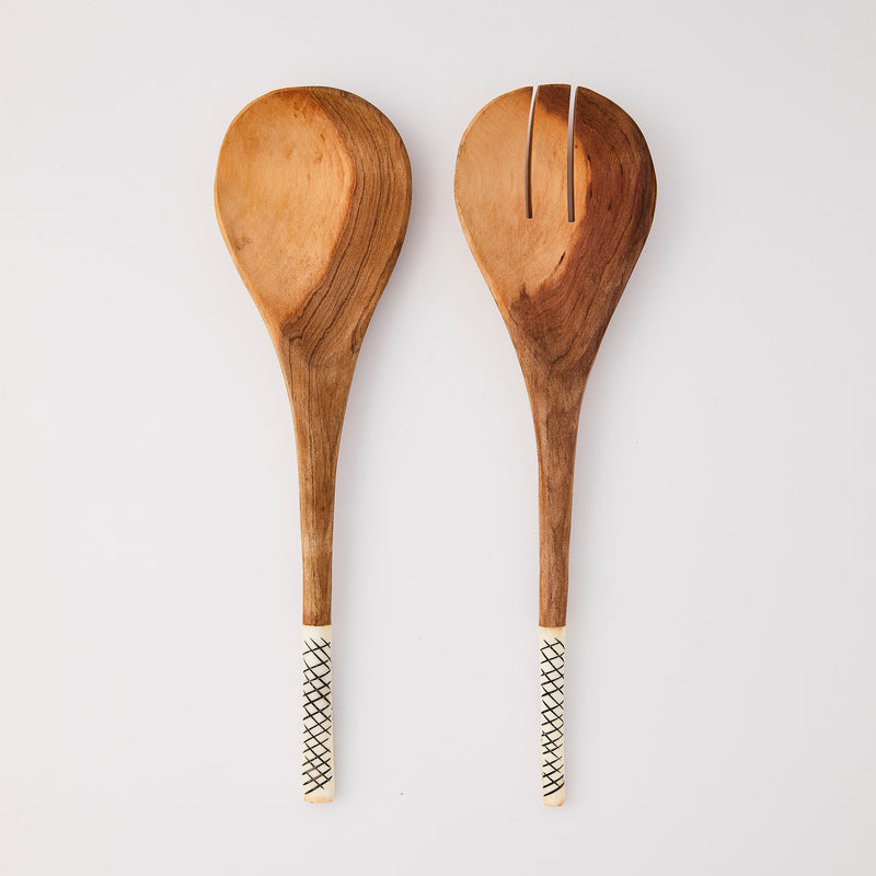 Wooden serving cutlery with white and black line design handle.