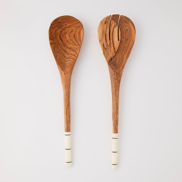 Wooden serving cutlery with white and black line design handle.