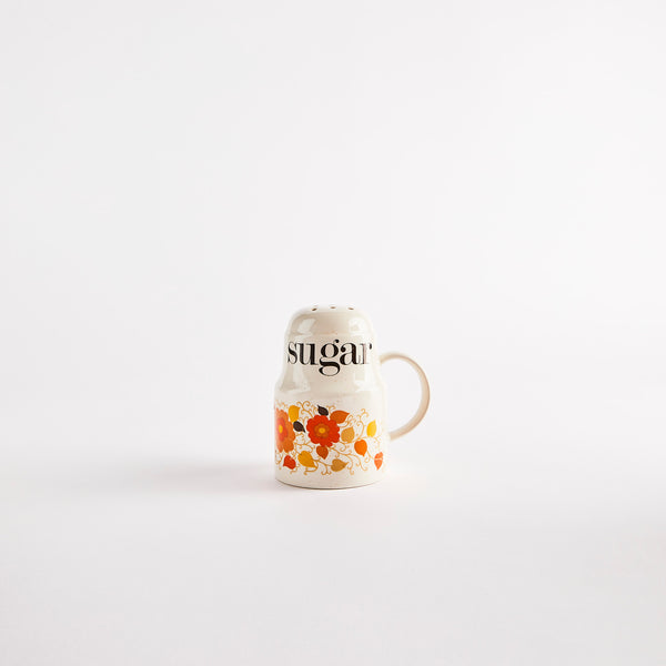 Vintage floral shaker with "sugar" text.