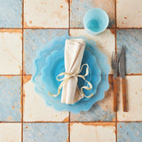 Top view of blue marble table setting on blue and cream tile background.