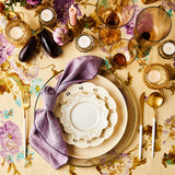 Top view of table setting surrounded by candles, glassware on floral and cream tablecloth.