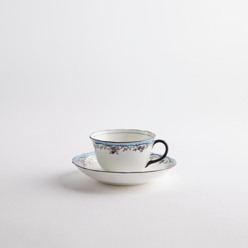 White with black, blue and pink vintage design tea cup and saucer.