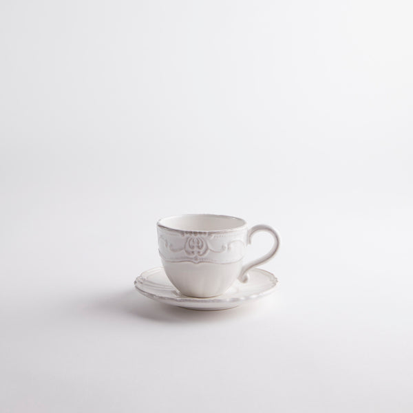 White tea cup with embossed design and saucer.