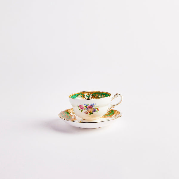 White teacup and saucer with multicolour floral print.