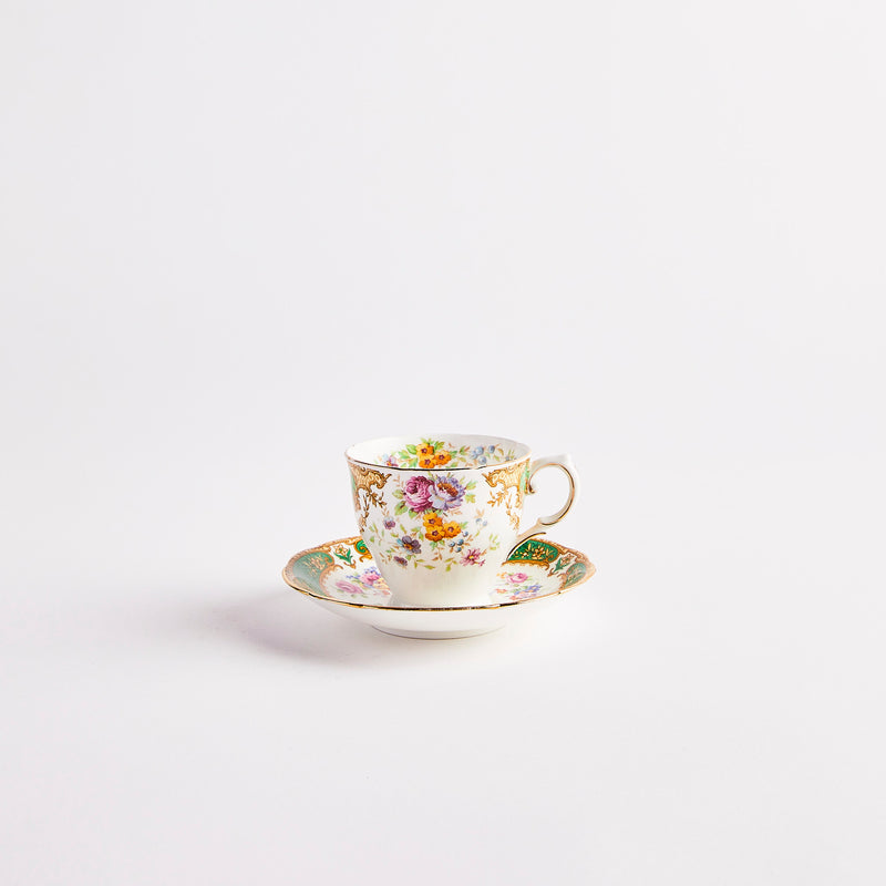 White teacup and saucer with multicolour floral print.