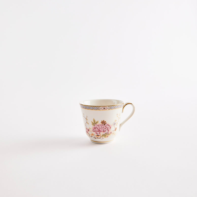 White teacup with floral design and gold rim.