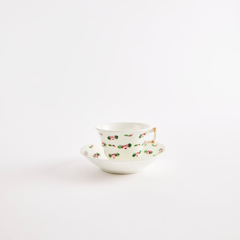 White teacup and saucer with floral design.