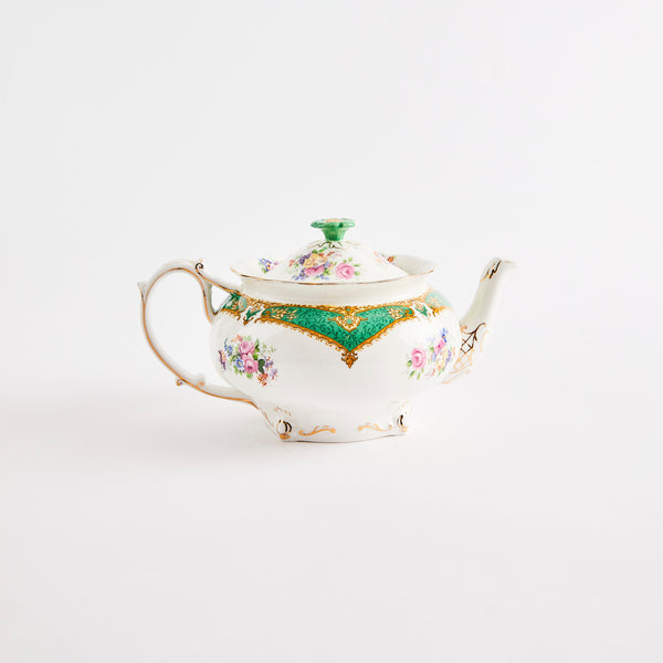 White teapot with green and gold floral design.