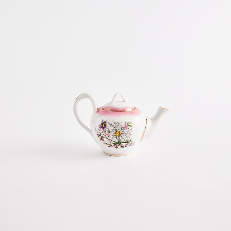 White teapot with pink and floral design.