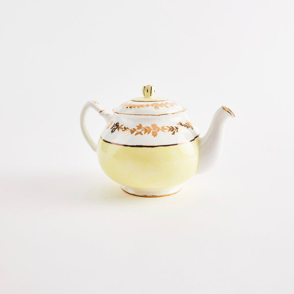 White and yellow teapot with gold detail.