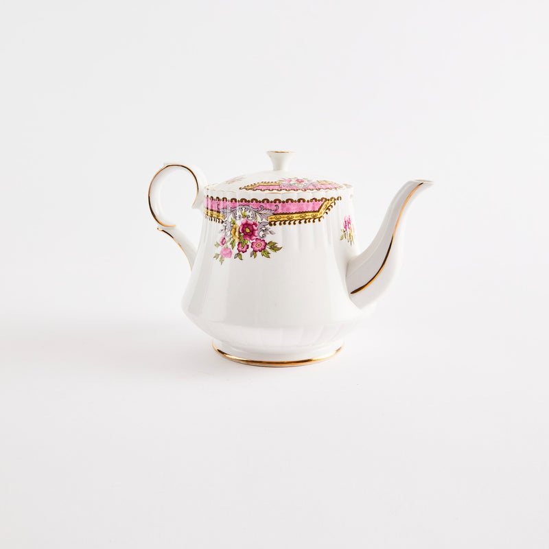 White teapot with pink floral design and gold rim.