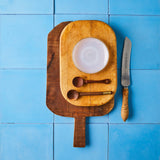 Top view of cutting boards and utensils on blue tiled background. 