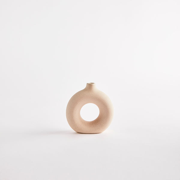 Beige circular with hole in middle vase.