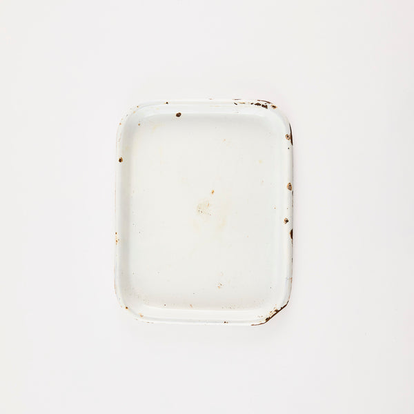 White vintage baking tray with worn edges.