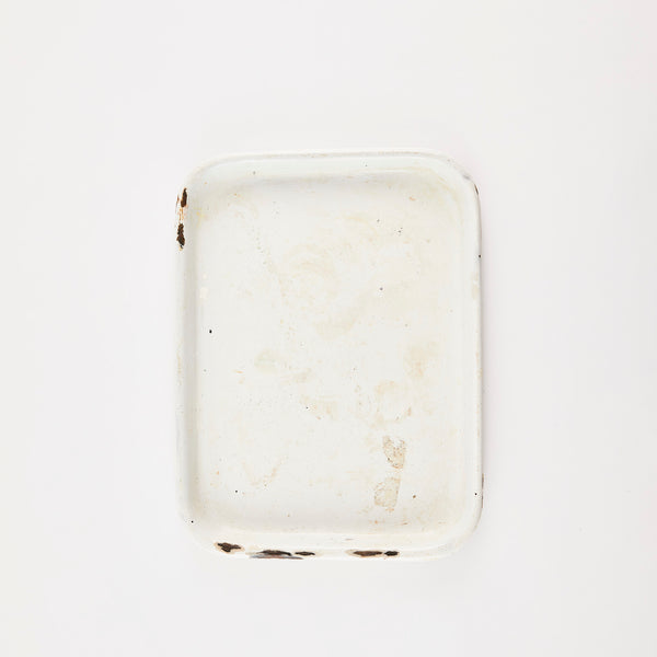 White vintage baking tray with worn edges.