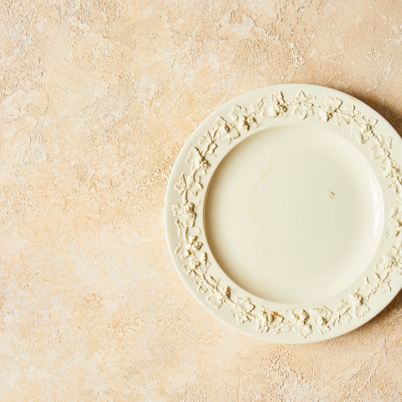 Top view of cream plate on Painted Textured Warm Sunshine Background.